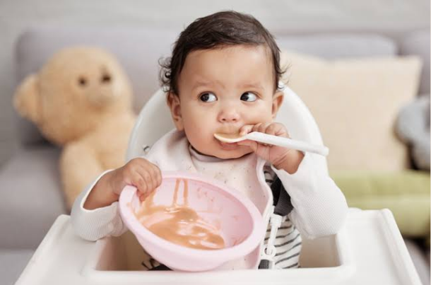 when do babies use a spoon